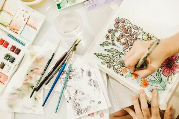 An artist drawing flowers by hand with watercolors