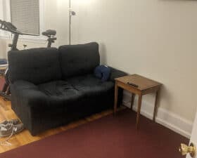 A photo of a living room couch in a city apartment at night